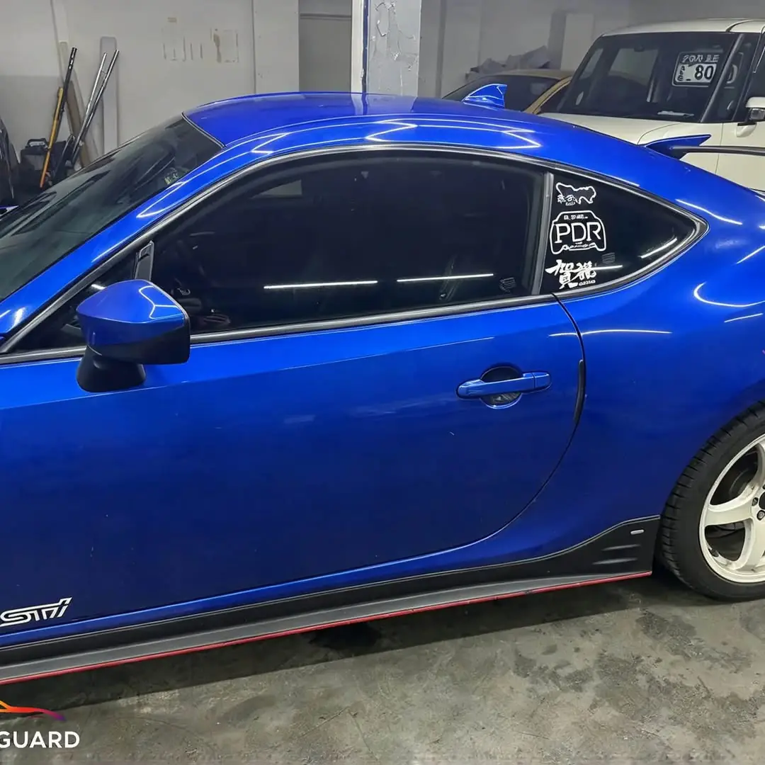 Blue Subaru BRZ side profile with tinted windows