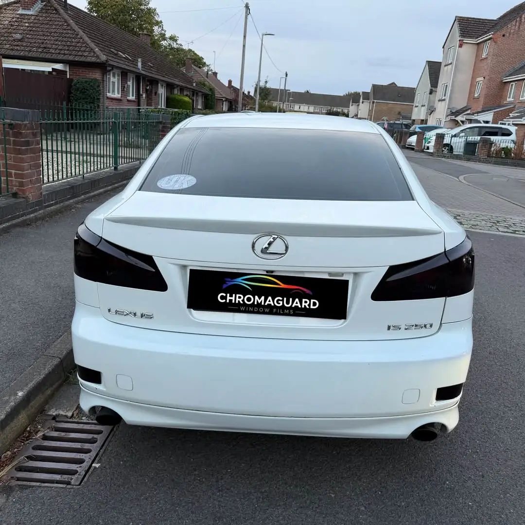 Rear of a white Lexus IS with tinted rear screen and smoked tail lights