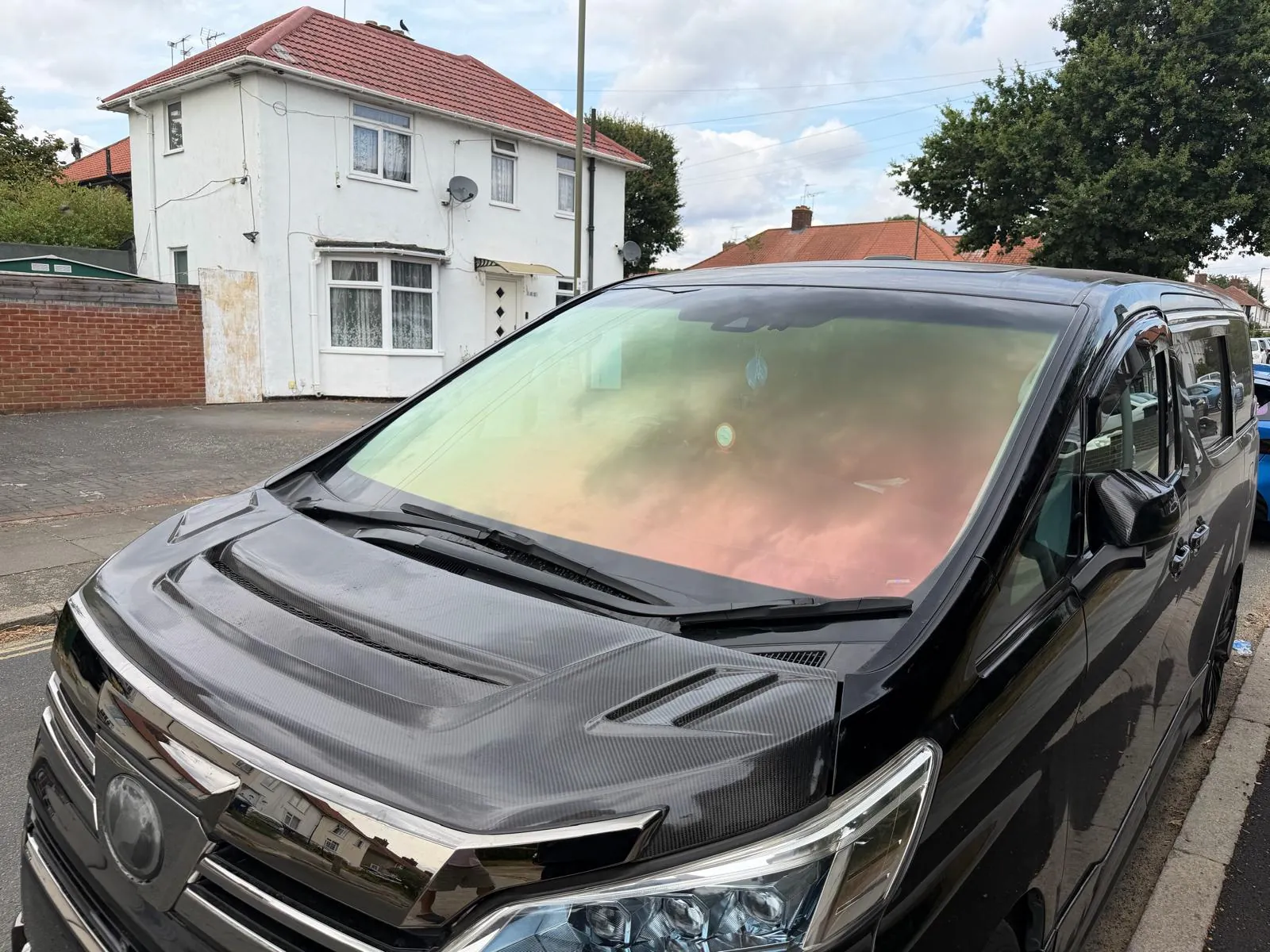 Black Toyota MPV with a Crimson Ember Red chameleon windscreen